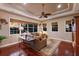 Comfortable living room features a ceiling fan, hardwood floors, and large windows offering great natural light at 13635 Legends Walk Ter, Lakewood Ranch, FL 34202