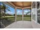Screened-in patio overlooking the green golf course, pond and palm trees in the distance at 13635 Legends Walk Ter, Lakewood Ranch, FL 34202