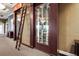 Sophisticated wine storage room with glass doors, a wooden ladder, and ample space for a large collection at 13635 Legends Walk Ter, Lakewood Ranch, FL 34202