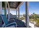 Breezy balcony featuring comfortable chairs and a serene view of the ocean and lush greenery at 137 Big Pass Ln, Sarasota, FL 34242