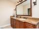 Bathroom featuring granite countertops, dual sinks, decorative mirror, and dark wood cabinetry at 137 Big Pass Ln, Sarasota, FL 34242