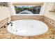Relaxing bathroom with a large soaking tub with granite tile and a view of the neighborhood at 137 Big Pass Ln, Sarasota, FL 34242
