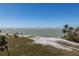 Scenic view of a beachfront with palm trees, ocean, sand, and shoreline, offering a serene and coastal atmosphere at 137 Big Pass Ln, Sarasota, FL 34242