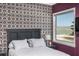 A bedroom with an accent wall, views of the beach, and a queen sized bed with decorative pillows at 137 Big Pass Ln, Sarasota, FL 34242