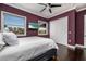 Bedroom with hardwood floors, windows with beach views, a TV, and a ceiling fan at 137 Big Pass Ln, Sarasota, FL 34242