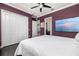 This primary bedroom has hardwood floors, white closets, beach view TV, and a doorway to the primary bath at 137 Big Pass Ln, Sarasota, FL 34242