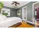 This bedroom has warm wood floors, gray walls, and doorways leading to a bathroom and hallway at 137 Big Pass Ln, Sarasota, FL 34242