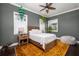 Bright bedroom features wood flooring, a ceiling fan, and colorful accents with natural light from two windows at 137 Big Pass Ln, Sarasota, FL 34242