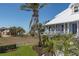 Exterior view of charming beach cottage with green yard and palms at 137 Big Pass Ln, Sarasota, FL 34242