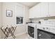 Well-lit laundry room with modern washer and dryer, ample storage, and window view at 137 Big Pass Ln, Sarasota, FL 34242