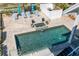 Aerial view of a private swimming pool with a hot tub and lounge chairs, surrounded by manicured landscaping at 137 Big Pass Ln, Sarasota, FL 34242