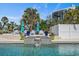 Outdoor pool with water feature, surrounded by lush plantings and seating, offering a serene and luxurious retreat at 137 Big Pass Ln, Sarasota, FL 34242