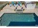 Aerial view of a backyard pool area with a tiled patio, sun loungers, and a decorative water feature at 137 Big Pass Ln, Sarasota, FL 34242