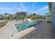 Inviting pool area featuring a stone patio, lush landscaping, and stylish outdoor furniture, perfect for relaxation and entertainment at 137 Big Pass Ln, Sarasota, FL 34242