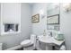 Charming powder room with pedestal sink, mosaic tile floor, and natural light at 137 Big Pass Ln, Sarasota, FL 34242