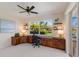Bright home office features built-in desk space, cabinets, and sliding door access to the lanai at 13809 Milan Ter, Lakewood Ranch, FL 34202
