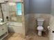 Bathroom with a tiled shower and tub, tile floors, and a modern toilet at 1534 25Th St, Sarasota, FL 34234