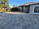 Paver driveway leading to a charming gray house with well-maintained landscaping and a black iron fence at 1534 25Th St, Sarasota, FL 34234