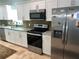 Well-equipped kitchen with stainless steel appliances and white cabinets, complemented by granite countertops at 1534 25Th St, Sarasota, FL 34234
