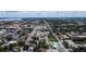 Wide aerial shot of a lively city street lined with stores, buildings, and tennis courts and lush greenery all around at 1704 Ballard Park Dr, Bradenton, FL 34205