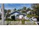 Quaint blue home with neat landscaping and a welcoming white picket fence at 1704 Ballard Park Dr, Bradenton, FL 34205