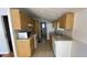 Galley kitchen featuring wood cabinets, white appliances and tile floors at 1704 Ballard Park Dr, Bradenton, FL 34205