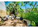 Lush backyard retreat featuring a cozy fire pit, Adirondack chairs, mature trees, and a relaxing hot tub at 1739 Oak St, Sarasota, FL 34236
