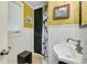 Charming bathroom features beadboard wainscoting, yellow wallpaper, and a pedestal sink at 1739 Oak St, Sarasota, FL 34236