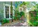 Charming front entrance with lush greenery, brick pathway, and decorative wrought iron gate adding curb appeal at 1739 Oak St, Sarasota, FL 34236