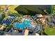 Aerial view showcases tennis courts and the pool area with lounge chairs and lush landscaping near residential area at 17440 Hampton Falls Ter, Bradenton, FL 34202