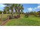 A fenced backyard with lush green grass and beautiful tropical landscaping creates a private outdoor oasis at 17440 Hampton Falls Ter, Bradenton, FL 34202