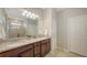 Bathroom featuring double sinks with granite countertop, wood cabinets, tile flooring and glass enclosed shower at 17440 Hampton Falls Ter, Bradenton, FL 34202