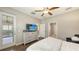 Bedroom with hardwood floors, a dresser with a TV, and access to the outside at 17440 Hampton Falls Ter, Bradenton, FL 34202