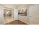 Hallway showcasing wood flooring, a wall painting, and doorway leading to a living room area at 17440 Hampton Falls Ter, Bradenton, FL 34202
