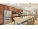 The kitchen has stainless steel appliances and a large granite island with seating at 17440 Hampton Falls Ter, Bradenton, FL 34202