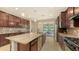 Modern kitchen with a large island, dark wood cabinets, granite countertops, and stainless steel appliances, perfect for cooking at 17440 Hampton Falls Ter, Bradenton, FL 34202