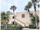 Inviting condo exterior with palm trees and a convenient staircase entrance to the units above the ground floor at 182 Pineneedle Dr # 182, Bradenton, FL 34210