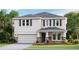 Charming two-story home featuring a stone veneer base, attached two car garage, and lush landscaping at 18320 Thistleberry Pl, Lakewood Ranch, FL 34211
