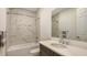 Bathroom featuring modern vanity, bathtub with marble-look tile surround, and chrome fixtures at 2015 Bolsena St, Nokomis, FL 34275