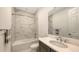 Bathroom featuring modern vanity, bathtub with marble-look tile surround, and chrome fixtures at 2015 Bolsena St, Nokomis, FL 34275