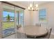 Charming dining area with a view of the backyard and a stylish chandelier at 2015 Bolsena St, Nokomis, FL 34275