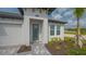 Elegant front entrance featuring a stylish door, white trim windows, and lush landscaping at 2015 Bolsena St, Nokomis, FL 34275