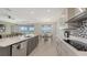 Open kitchen with stainless steel appliances, modern lighting, and seamless flow to the living area at 2015 Bolsena St, Nokomis, FL 34275