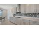 Bright kitchen with stainless steel hood and appliances, quartz countertops, and tile backsplash at 2015 Bolsena St, Nokomis, FL 34275