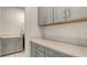 Bright laundry room featuring gray cabinetry, counter space, and modern finishes at 2015 Bolsena St, Nokomis, FL 34275