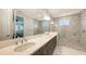 Modern main bathroom with double vanity, marble tile, and glass walk-in shower at 2015 Bolsena St, Nokomis, FL 34275