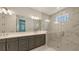 Modern main bathroom with double vanity, marble tile, and glass walk-in shower at 2015 Bolsena St, Nokomis, FL 34275