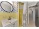 Bright bathroom featuring yellow tile, decorative wallpaper, with shower and white vanity at 2105 Hibiscus St, Sarasota, FL 34239