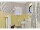 Charming bathroom featuring yellow tile, decorative wallpaper, and a round mirror above the vanity at 2105 Hibiscus St, Sarasota, FL 34239