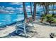 Inviting park bench offers a serene view of the clear turquoise water and lush tropical foliage under a bright sky at 2105 Hibiscus St, Sarasota, FL 34239